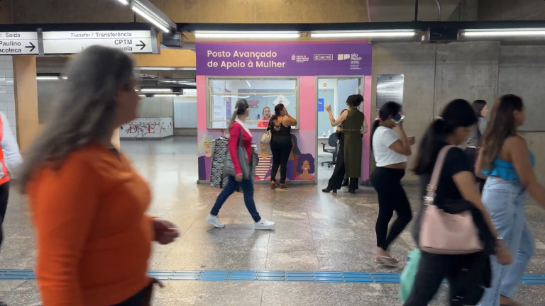 Posto Avançado do Metrô, uma cabine lilás, com passageiras do Metrô andando. Lugar serve para atendimento a casos de importunação sexual