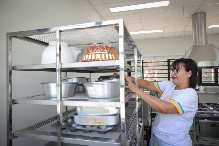Mulher na cozinha pegando panela